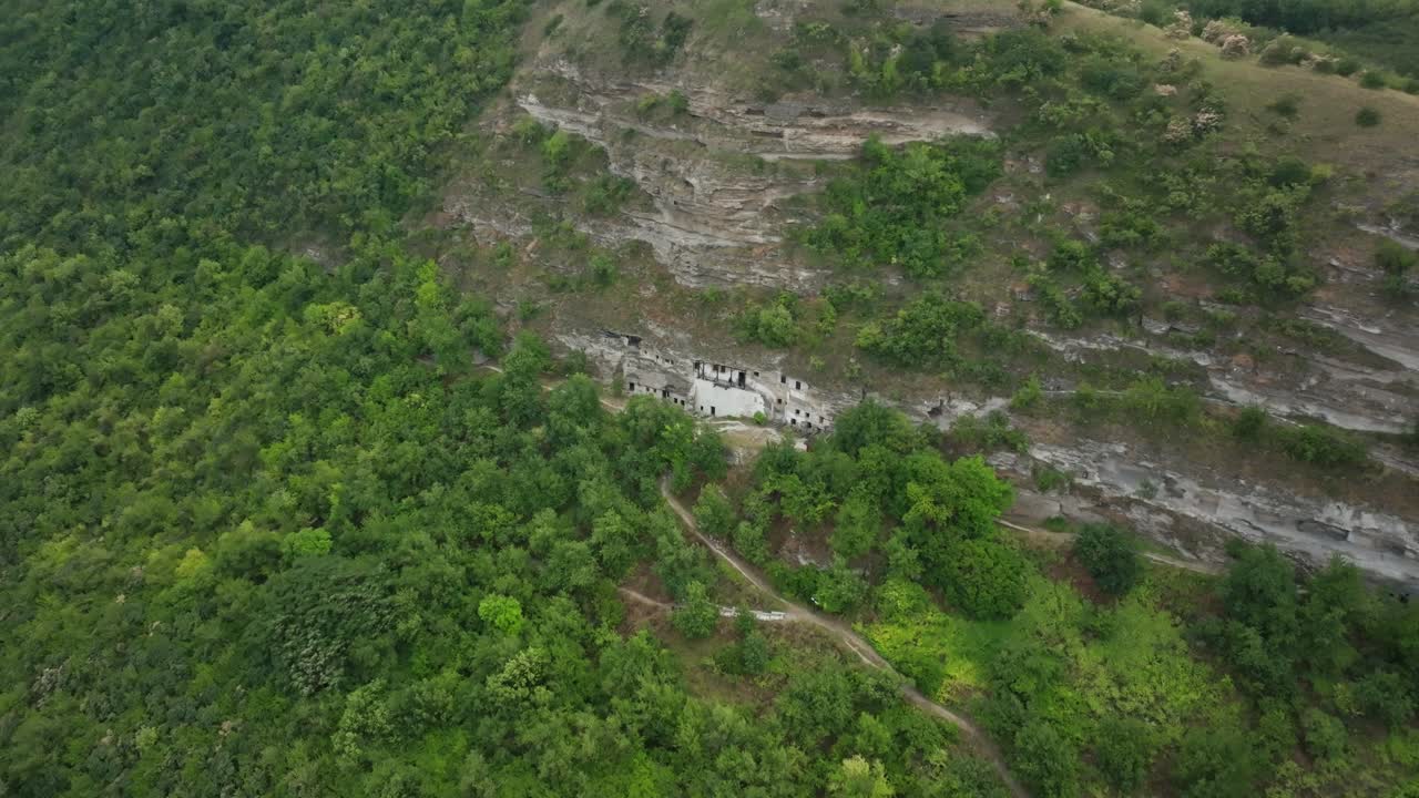 acercándose a la ladera de la montaña, desde donde las estructuras hechas por el hombre en las rocas son gradualmente visibles, agujeros en la piedra donde la gente vive celdas para eremitas