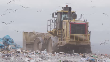 Vehicles-clearing-rubbish-piled-on-a-landfill-full-of-trash--