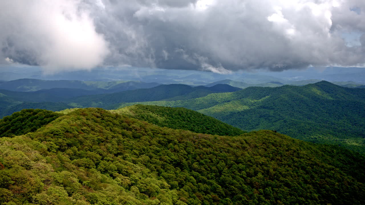 High drone flight through cloud layers hovering above wet Smoky terrain