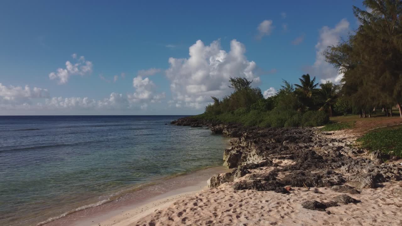 tomada de drone de bajo ángulo de la playa de arena blanca rocosa en la isla de tinian