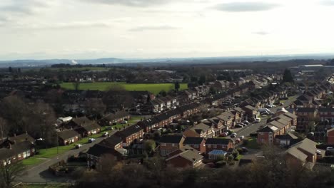 casas rurales de barrio de casas adosadas británicas con vistas aéreas de espacios verdes a través del horizonte de la montaña snowdonia, orbitando a la izquierda