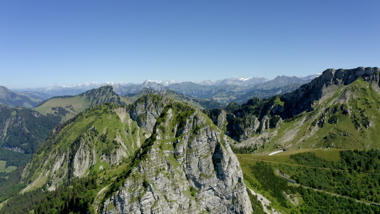 sobrevolando la cumbre de dent de jaman en los alpes suizos sobre montreux en vaud, suiza con cielo azul de fondo - drone aéreo