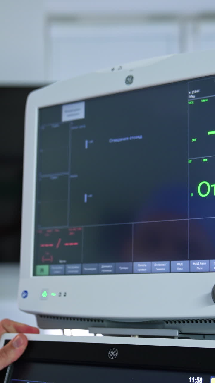 Doctor's hand turn the screens of lung ventilator system. The monitors are switched on and ready for usage. Blurred backdrop. Vertical video