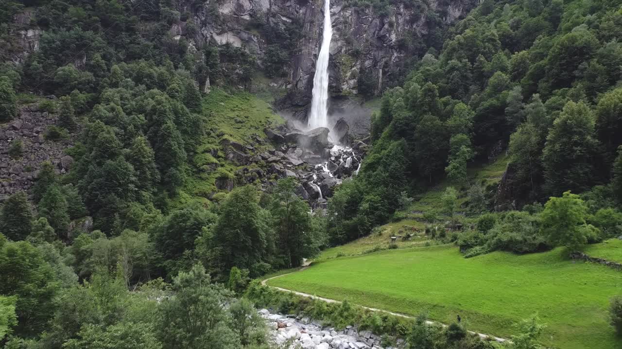 Paradiso in Terra: cascata in una profonda valle tra le montagne svizzere, vista aerea in allontanamento