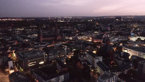 Mainz-City-center-from-a-drone-view-showing-the-Dome-in-the-dark-and-the-city-lights-coming-up