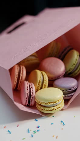 pink paper bag filled with colorful macarons