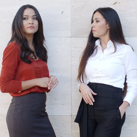 Two-chic-young-women-standing-chatting