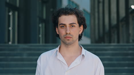 portrait of a young man looking at camera outdoors