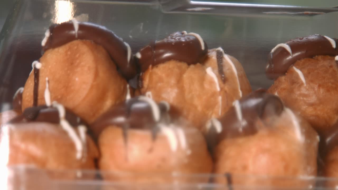 enfoque en profiteroles de lujo con relleno de crema batida y cubierta de chocolate