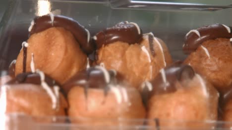 focus pull to luxurious profiteroles with whipped cream filling and chocolate topping