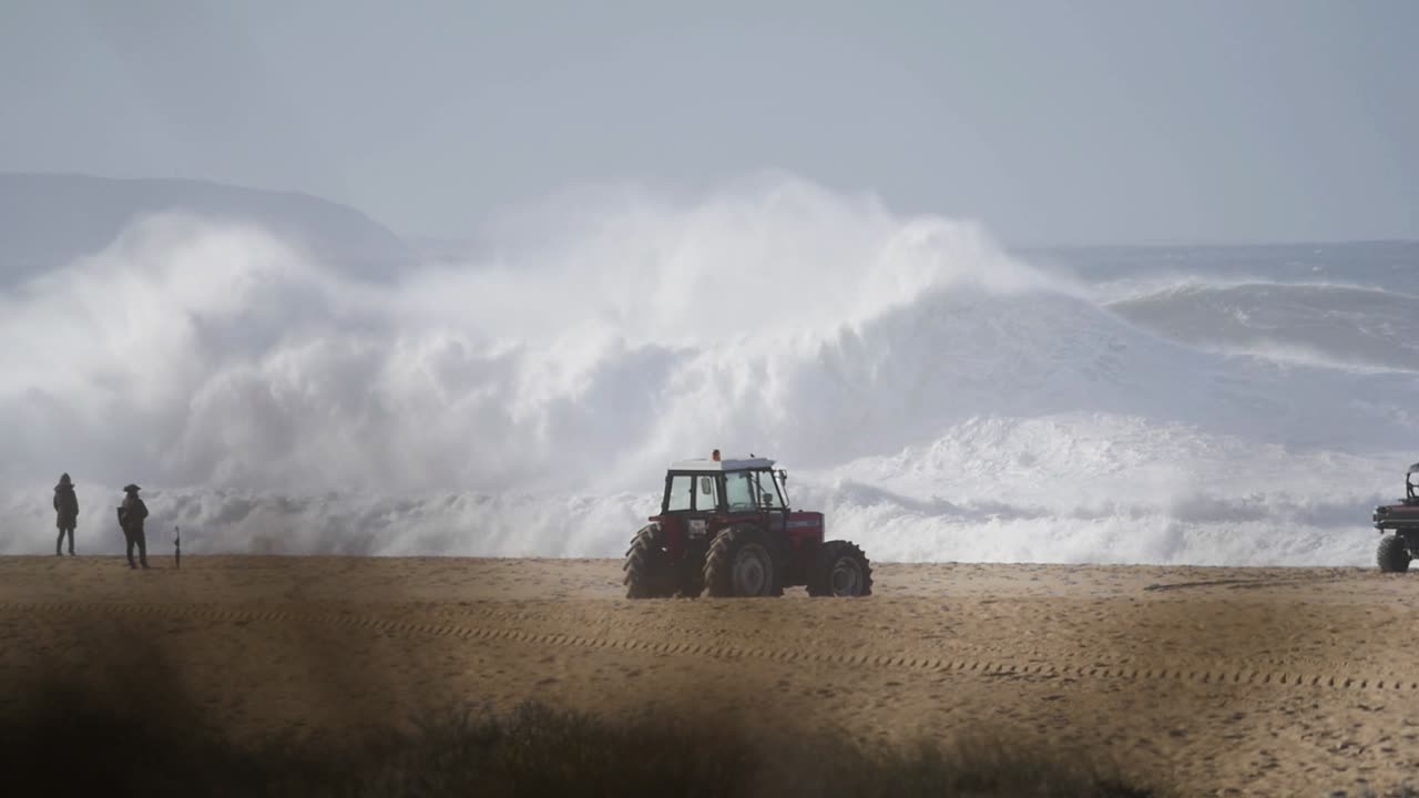 Slow motion of a wave break on the beach in Nazaré, Portugal. Nazaré is a small village in Portugal with the biggest waves in the world.