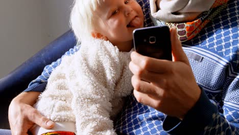 father and son taking selfie with mobile phone 4k