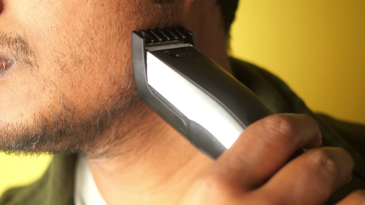 Man die zijn baard trimt met een elektrische trimmer
