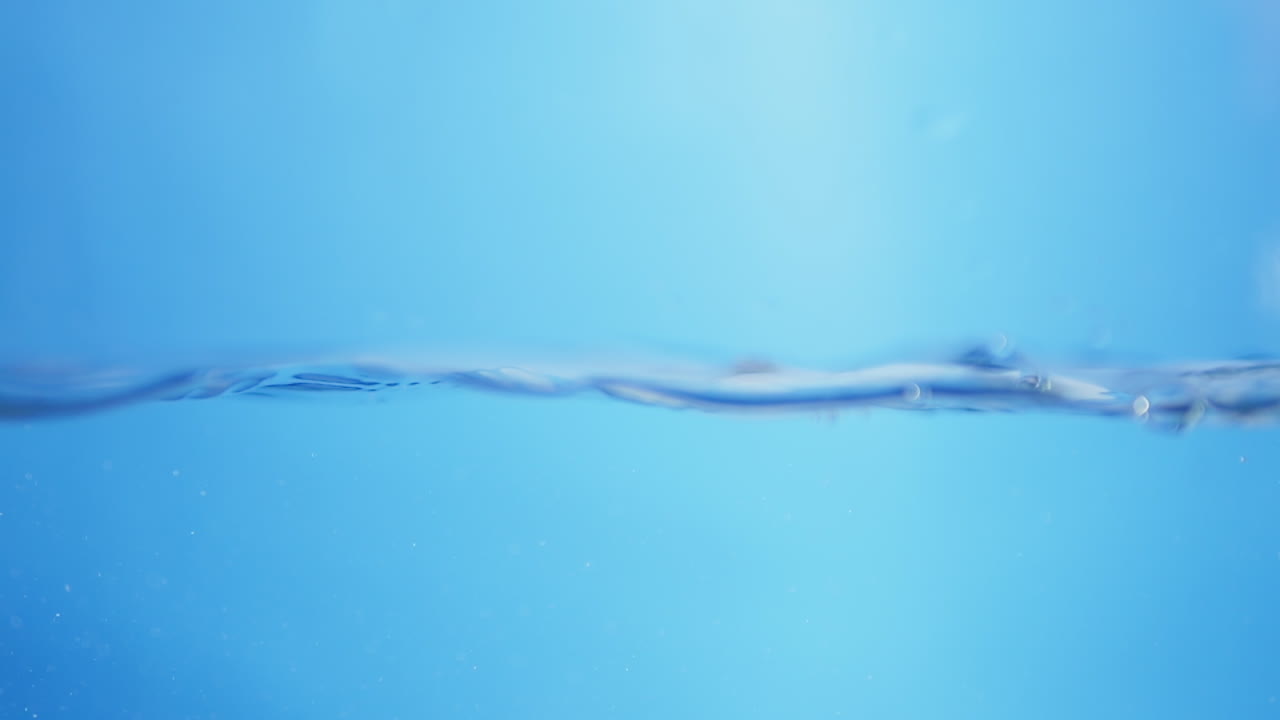 거품이 은 물을 통해 추상적이고 수중적인 시각으로 상승하여 깨함, 유동성, 그리고 자연의 흐름을 나타니다.