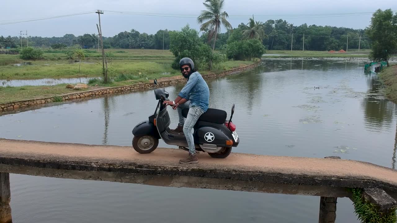 Motorbike rider crossing a village bridge,India,Crossing river,Small Bridge,Posing,Aerial shot,River