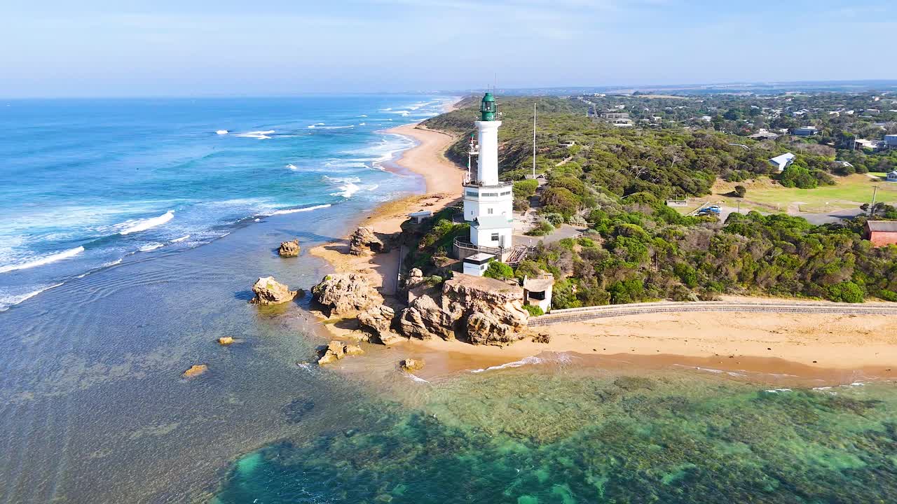 Aerial views of Point Lonsdale Lighthouse and surrounding coastline in bright daylight, showcasing natural beauty and architectural elegance
