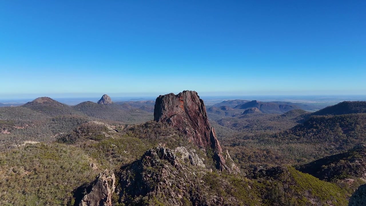 ワランバングル国立公園の澄み切った青空の下、火山岩の岩層を捉えた広角空撮。