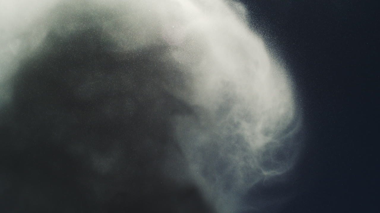 Nighttime blowhole spray captured in slow motion with illuminated mist against darkness