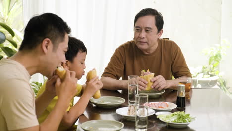 Hombres-Asiáticos-Y-Niño-Sentado-En-La-Mesa