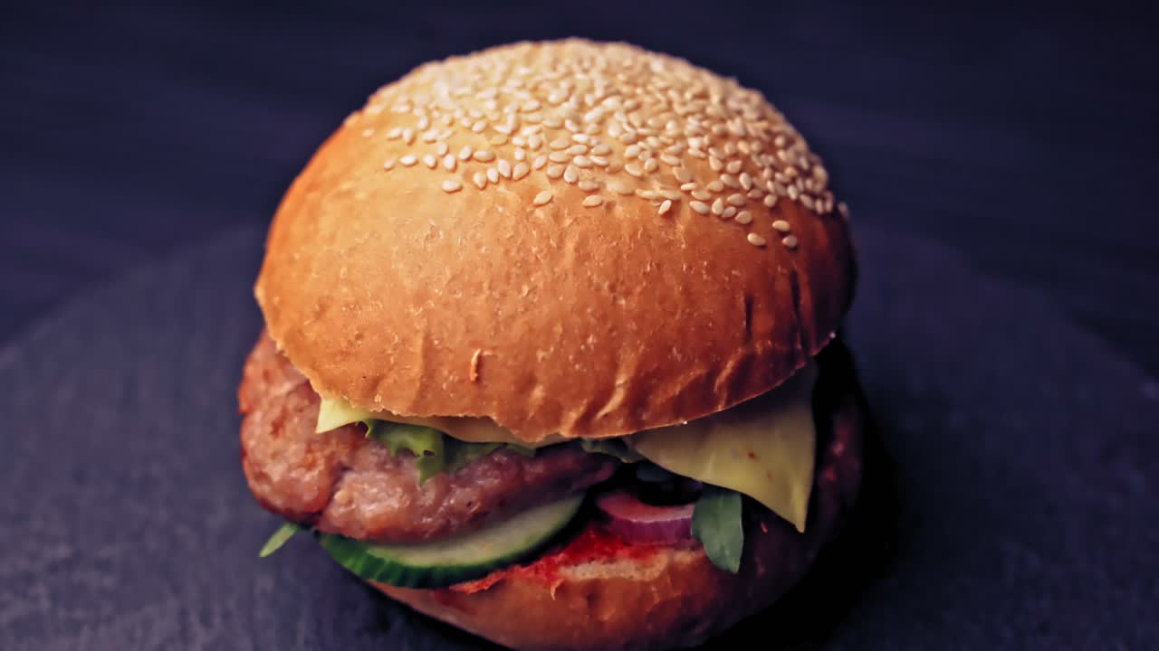 Fresh appetizing hamburger rotating on black background. Delicious grilled burgers
