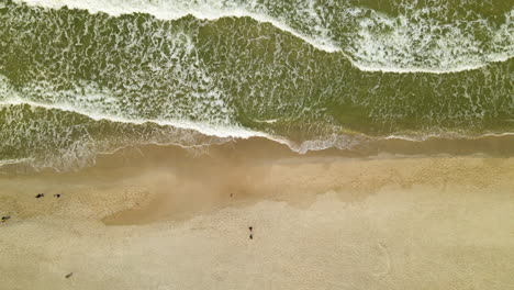 Olas-Espumosas-Blancas-En-La-Orilla-Del-Mar-Con-Turistas-Caminando-Durante-El-Día-En-Wladyslawowo,-Polonia