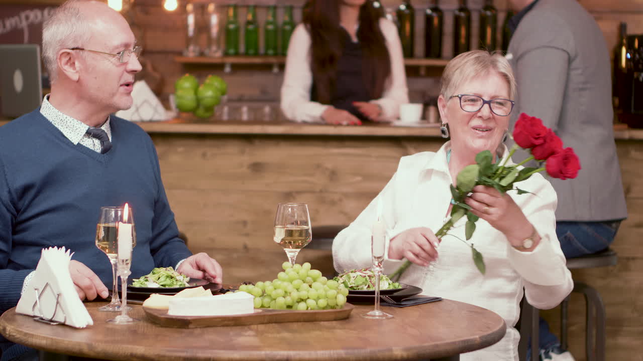 Couple celebrating in a restaurant with roses and wine