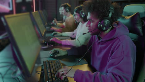 zoom in shot of a  team of cybersport gamers playing video games in a gaming club