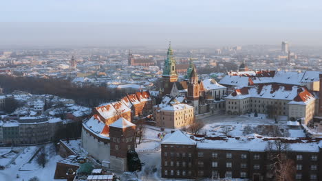 Panorama-Del-Castillo-De-Wawel-Cubierto-De-Nieve-Y-Del-Casco-Antiguo-En-Una-Mañana-Mágica-Con-Una-Suave-Luz-Solar-Durante-El-Invierno,-Cracovia,-Polonia