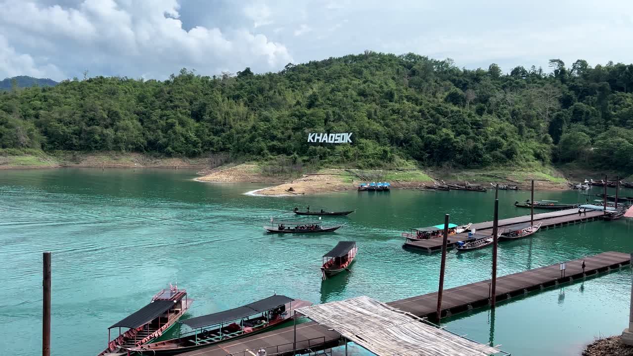 เรือหางยาวกำลังเทียบท่าที่ท่าเรืออุทยานแห่งชาติเขาสกในประเทศไทย