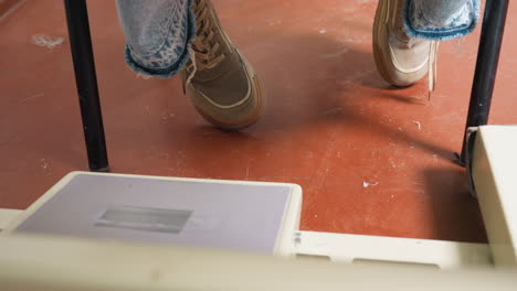 seamstress wearing jeans and sports shoe, foot on pedal controlling machine speed, ensuring precision, stable posture, demonstrating skillful operation for effective garment production