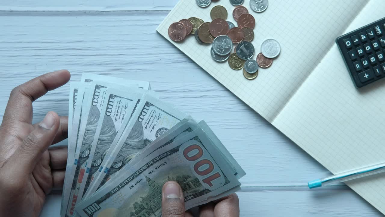 un primer plano de un hombre contando dinero a mano.