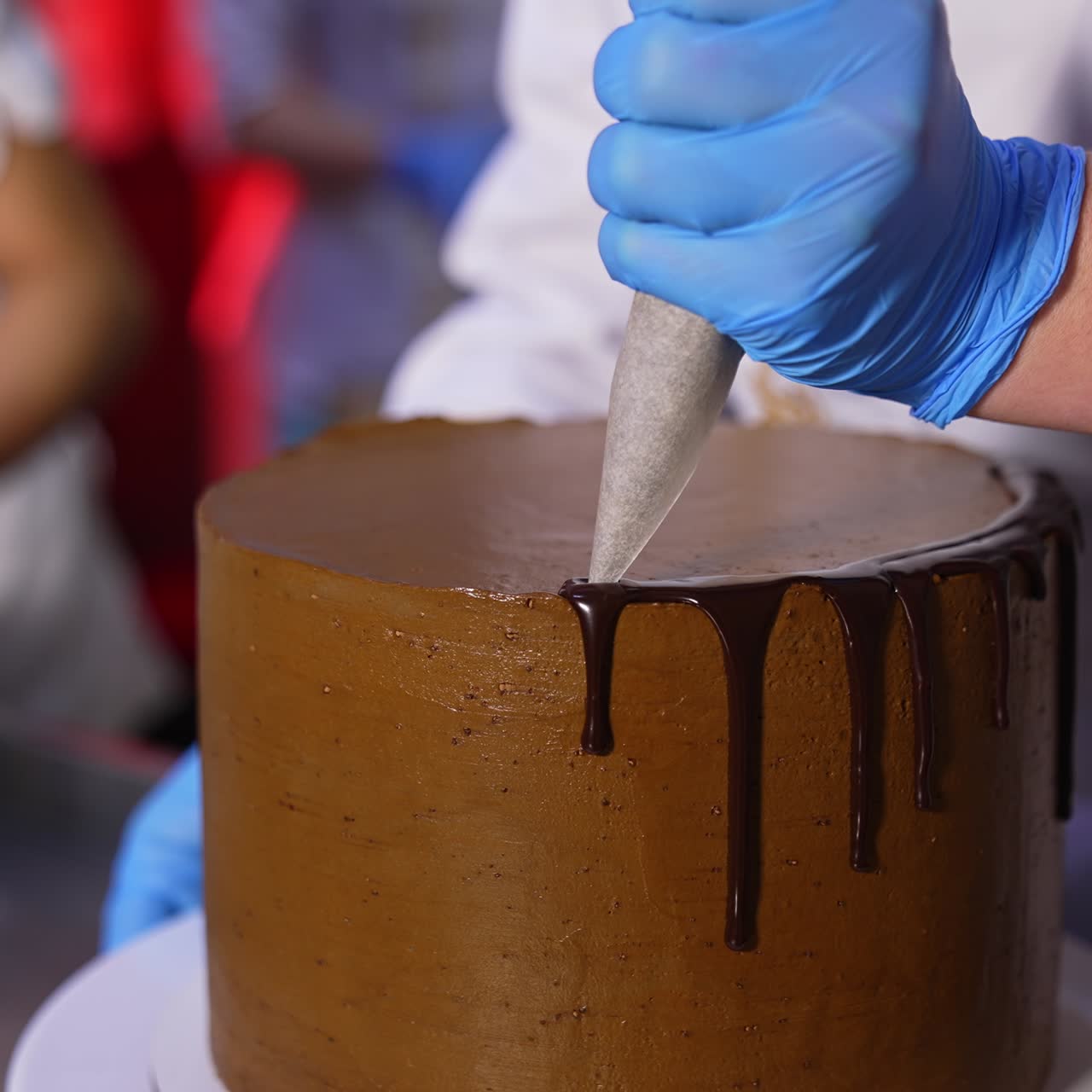 Decorazione di una torta con cioccolato liquido. Cioccolato fuso che cola dalla torta. Primo piano