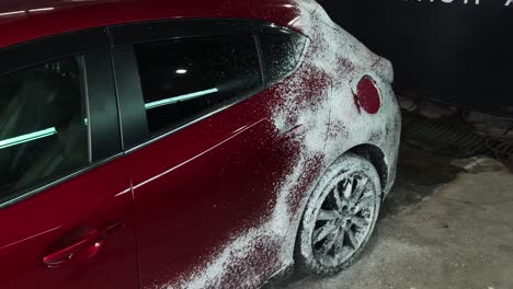 red car being foam washed at car wash