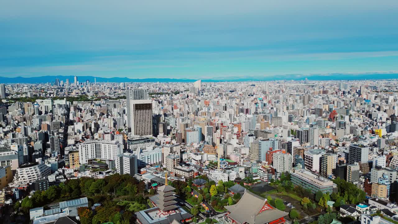 Drone pans left, Asakusa skyline with dense Tokyo buildings in soft daylight