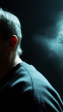 mysterious figure emerging from fog. a ghostly figure with white hair appears in a dense fog, creating an eerie and unsettling atmosphere in dim light.