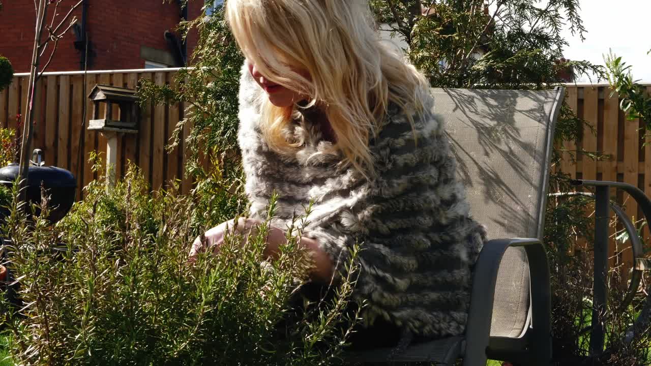 매력적인 여성이 정원에서 신선한 로즈마리 허브를 채취 중간 4k 촬영 느린 동작 초상화