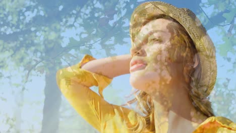 composite video of caucasian woman wearing a hat smiling against tall trees