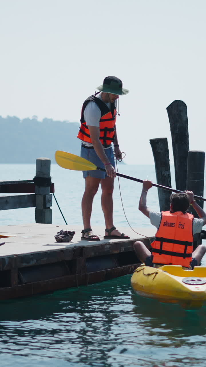 Persone che vanno in kayak da un molo