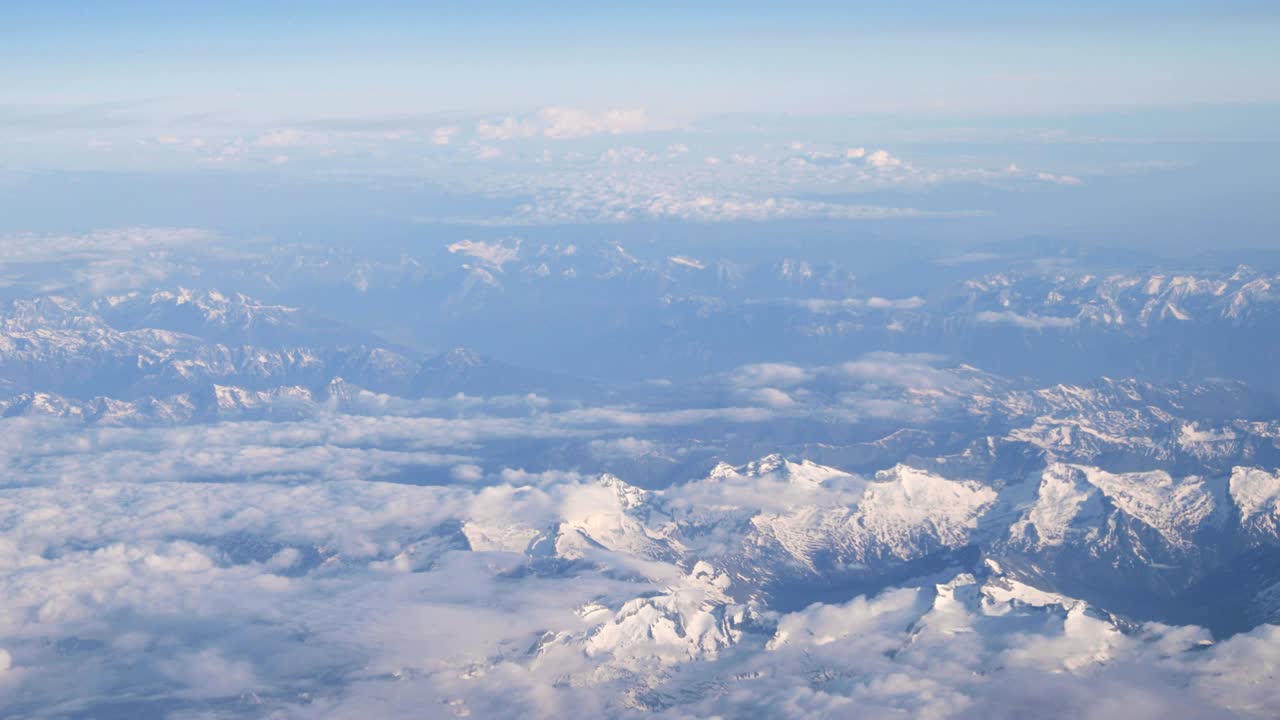 взгляд с окна самолета на заснеженную вершину татры в летний день.