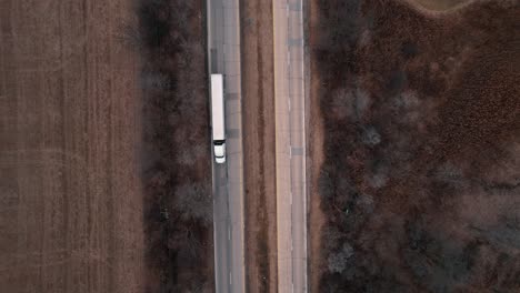 top down of a white semi-trailer truck speeds on ramp enetering interstate-highway i-94 illinois