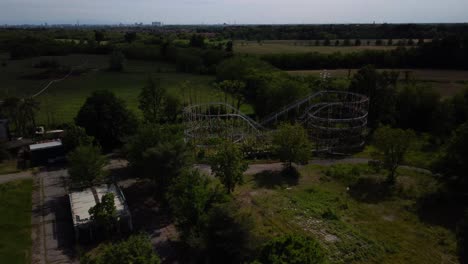 Aerial-shot-over-a-roller-coaster-ride-in-an-abandoned-park-in-Lunapark,-Limbiate