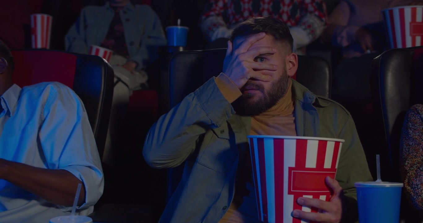 Bange mand ser en film i en biograf