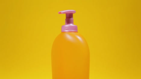 an orange soap dispenser plastic bottle on a rotating surface