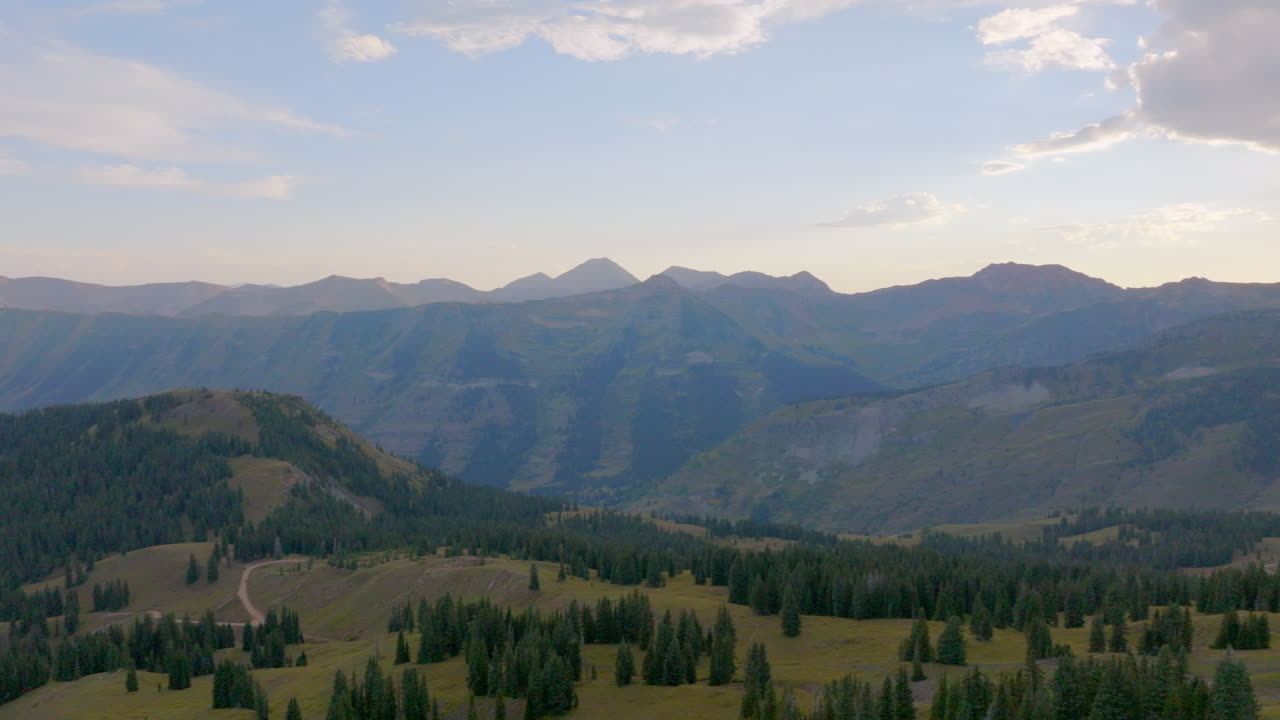Luftfoto af en bjergryg i Colorado Rockies med en panorering til venstre, der afslører en vandresti og en bjergkæde