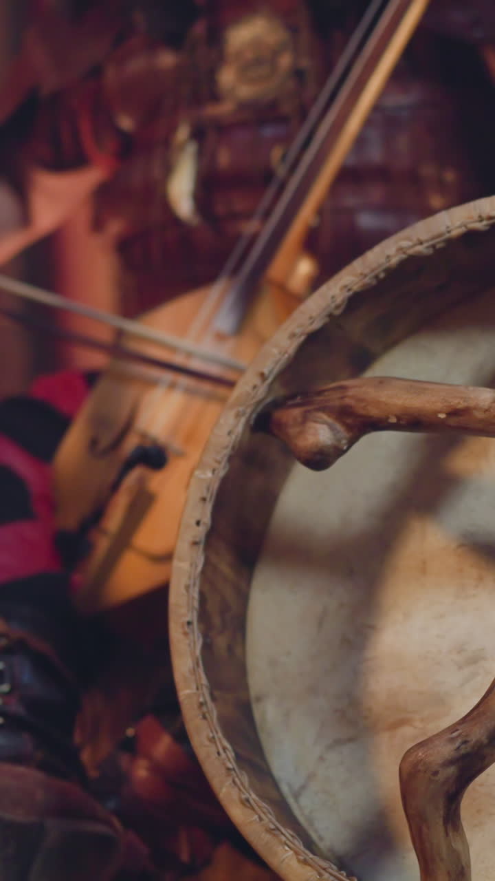 Man plays igil bow instrument on stage focus on shamanic tambourine closeup. Altai music traditions conservation. Ritual sound and inspiring show
