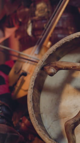 man plays igil bow instrument on stage focus on shamanic tambourine closeup. altai music traditions conservation. ritual sound and inspiring show