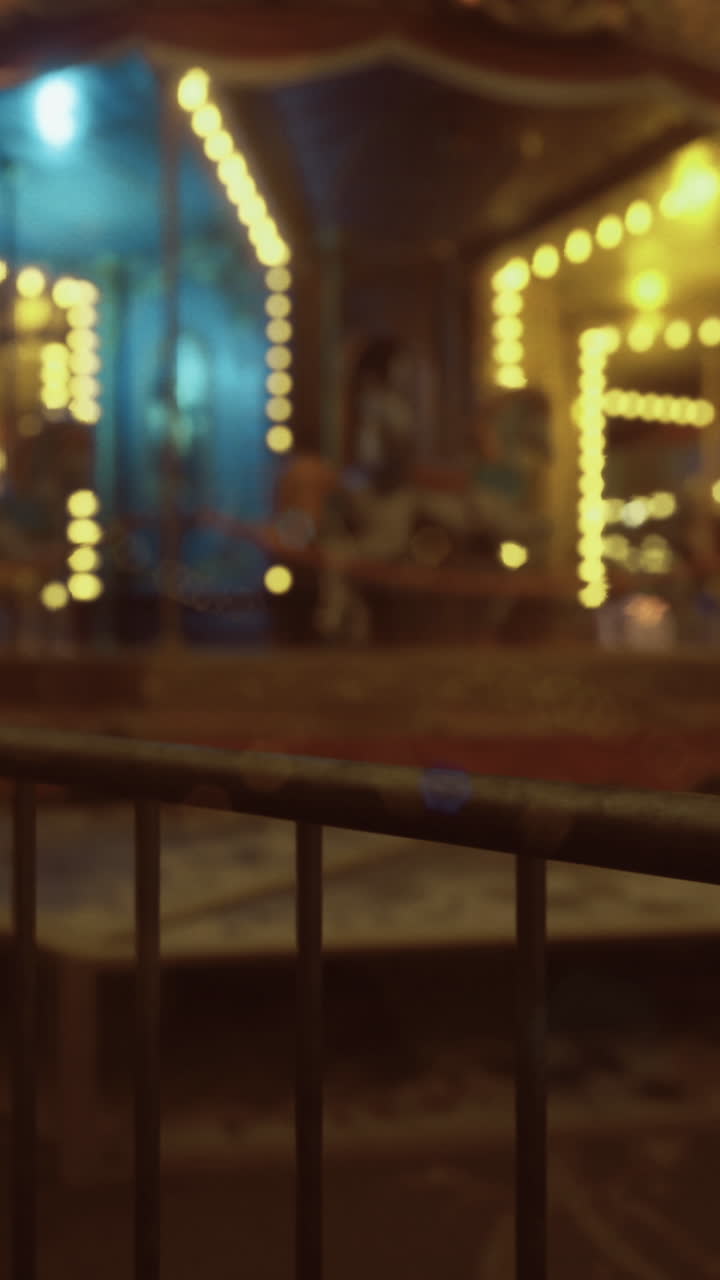 Nighttime carnival atmosphere illuminated with colorful lights and music