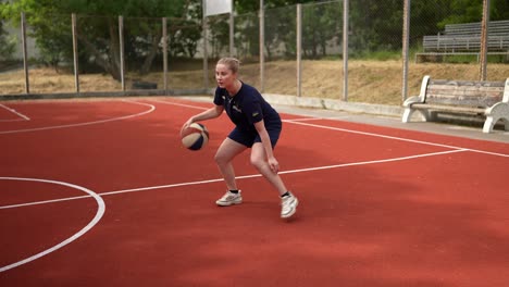 woman playing basketball outdoors