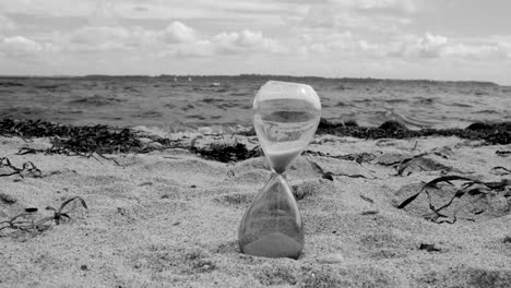 hour glas on the beach black and white