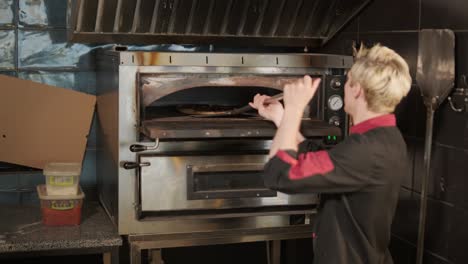 hombre cocinando pizza en la cocina de un restaurante